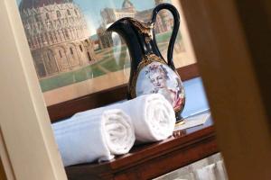 a vase and towels on a shelf with a picture at Casa Esvael Rooms in Verona