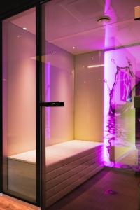 een kamer met een raam met paarse verlichting bij Akena Molinges - La Brocatelle in Saint-Claude