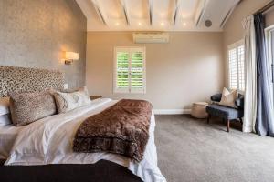 - une chambre avec un grand lit et une chaise dans l'établissement Luxe Family Home with Solar Power in Secure Hout Bay Estate, au Cap