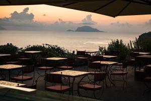 a group of tables and chairs with a view of the ocean at Hotel Signum in Malfa