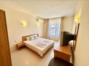 a hotel room with a bed and a television at Blue Marine - Menada Apartments in Sunny Beach