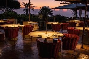 a group of tables and chairs with a sunset in the background at Hotel Signum in Malfa