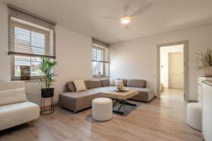 uma sala de estar com um sofá e uma mesa em Nauji apartamentai! Pamario 14 em Nida