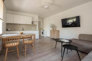 een keuken en een woonkamer met een bank en een tafel bij Nauji apartamentai! Pamario 14 in Nida