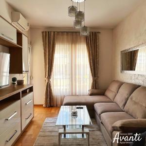 uma sala de estar com um sofá e uma mesa em Apartmani Avanti Budva em Budva