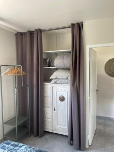 een slaapkamer met een bed en een kast met gordijnen bij VILLA M&M in La Seyne-sur-Mer