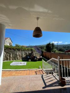 ein hängendes Licht hängt von einer Veranda mit Rasen in der Unterkunft Casa da Poza in Redondela