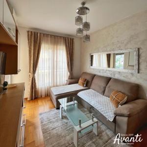 uma sala de estar com um sofá e uma mesa em Apartmani Avanti Budva em Budva