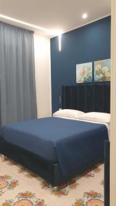 a bedroom with a large blue bed in a room at Dafne Home in Pompei