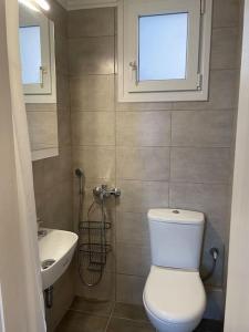 a bathroom with a white toilet and a sink at Acropolis Panorama Studio in Athens