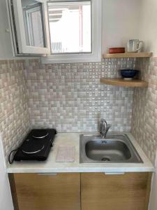 a kitchen counter with a sink and a window at Acropolis Panorama Studio in Athens