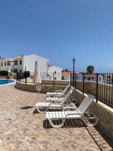 a row of lounge chairs sitting next to a pool at Bouganvilla in Adeje