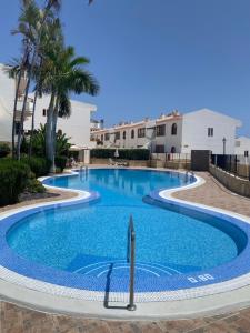 a swimming pool in a resort with palm trees at Bouganvilla in Adeje