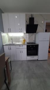 a kitchen with white cabinets and a black stove at Holiday apartment Kobuleti in K'obulet'i
