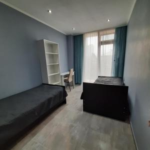 1 Schlafzimmer mit 2 Betten, einem Schreibtisch und einem Fenster in der Unterkunft Holiday apartment Kobuleti in Kobuleti