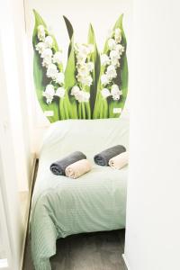 a room with a bed with white flowers on the wall at Lily Studio Apart *Top location* in Jerusalem