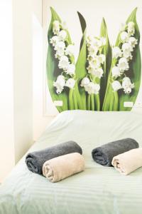 a bed with two towels on it with flowers at Lily Studio Apart *Top location* in Jerusalem