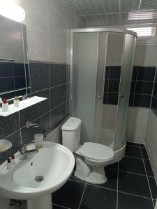 a bathroom with a toilet and a sink at Grand Clover Otel in Seyhan