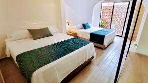 卡利的住宿－Hotel Casa Sab - San Fernando，一间卧室设有两张床和窗户。