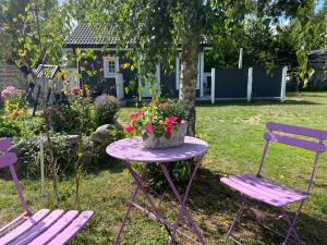 two purple chairs and a table with flowers on it at VillaAttefall in Färjestaden