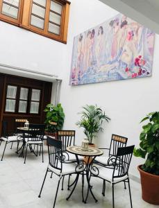 コルドバにあるCasa Qurtubaの壁画のテーブルと椅子
