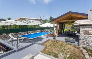 een achtertuin met een zwembad en een parasol bij 3 Bedroom Stunning Home In Tijarica in Vukići