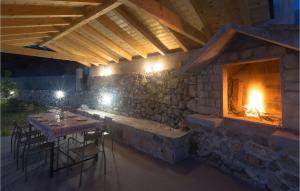 een stenen gebouw met een tafel en een open haard bij 3 Bedroom Stunning Home In Tijarica in Vukići