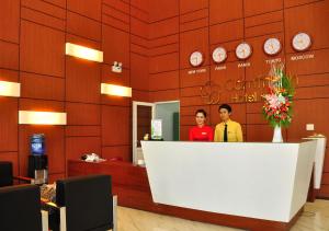 two people standing behind a counter in a hotel lobby at Cam Thanh Hotel in Quang Ngai