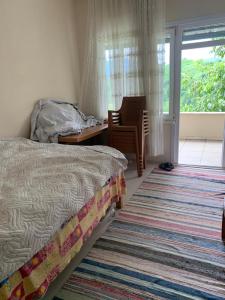 Schlafzimmer mit einem Bett, einem Schreibtisch und einem Fenster in der Unterkunft Rize manzara evi 
