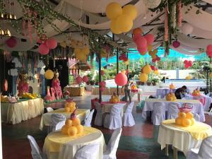 um salão de banquetes com mesas brancas e balões no tecto em Casa Michabella Leisure and Events Place em Supa