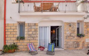 zwei Stühle vor einem Gebäude mit Balkon in der Unterkunft Amazing Home In Trappeto With Wifi in Trappeto