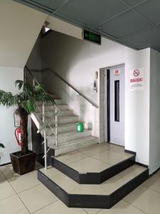 a staircase in a building with a green exit sign at Grand Clover Otel in Seyhan
