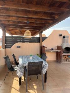 a patio with a table and chairs and an outdoor oven at ÁTICO Paraíso Beach con piscina privada in Vera