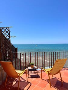 two chairs and a table on a patio overlooking the beach at Residenza Fontanelle-Beach Resort in Santa Maria di Castellabate