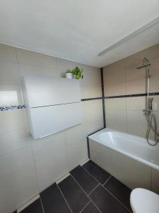 ein Badezimmer mit einer Badewanne, einem WC und einem Waschbecken in der Unterkunft Ferienwohnung Bodensee Nähe in Rielasingen-Worblingen