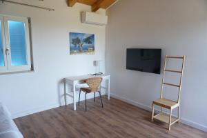 Televízia a/alebo spoločenská miestnosť v ubytovaní Farmhouse Cubani