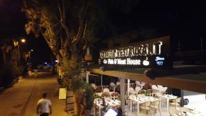 a man walking past a restaurant at night at trakheia butik otel in Marmaris
