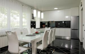 eine Küche mit einem weißen Tisch und weißen Stühlen in der Unterkunft Gorgeous Home In Imotski With Jacuzzi in Imotski