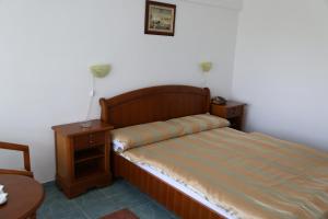 1 dormitorio con 1 cama y 2 mesitas de noche en Hotel Orfeu, en Mamaia