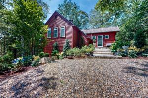 ein rotes Haus mit Kieseinfahrt davor in der Unterkunft Fernbank Hideaway in West Tisbury