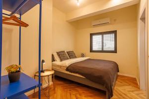 een slaapkamer met een bed, een bureau en een raam bij The Bograshov in Tel Aviv