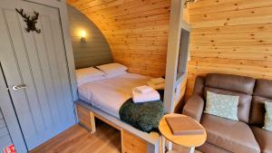 1 dormitorio pequeño con 1 cama y 1 sofá en Bothan Creag Sobhrag en Ballachulish