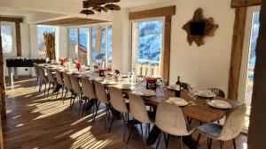 a long dining room with a long table and chairs at Chalet le Chantelevent for 24 Guests - Slope Views, Pool & Jacuzzi in Vars