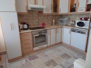 a kitchen with white cabinets and a stove top oven at Apartment 4 Kullat in Prizren
