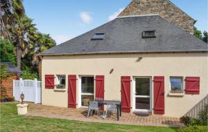 ein Haus mit roten Türen und einem Tisch davor in der Unterkunft 3 Bedroom Awesome Home In Lzardrieux in Lézardrieux