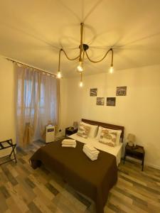 - une chambre avec un grand lit et un lustre dans l'établissement La casa dell’Appio, à Rome