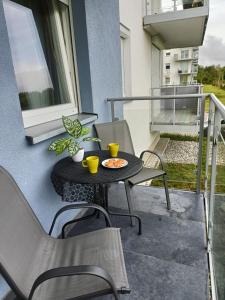 a patio with a table and chairs on a balcony at Luksusowy Apartament Mario Mare Kołobrzeg in Kołobrzeg