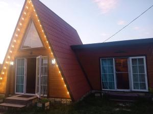 Una casa con luces de Navidad en un lado. en Quba A frame en Amsar