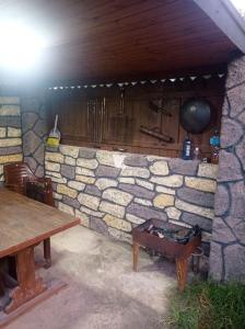 pared de piedra con mesa de madera y banco en Quba A frame en Amsar