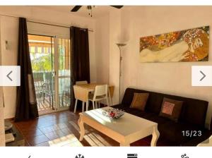 een woonkamer met een bank en een tafel bij Sahara Playa Barrosa in Chiclana de la Frontera
